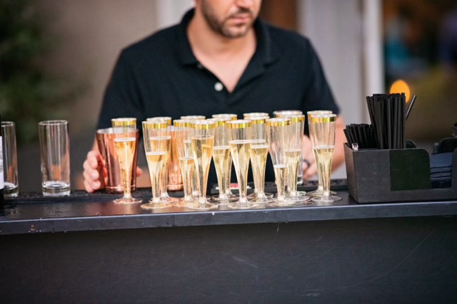 Glasses arranged on an event bar with a team member behind the counter