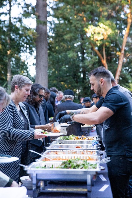 Italian Brothers team serving guests at an outdoor buffet
